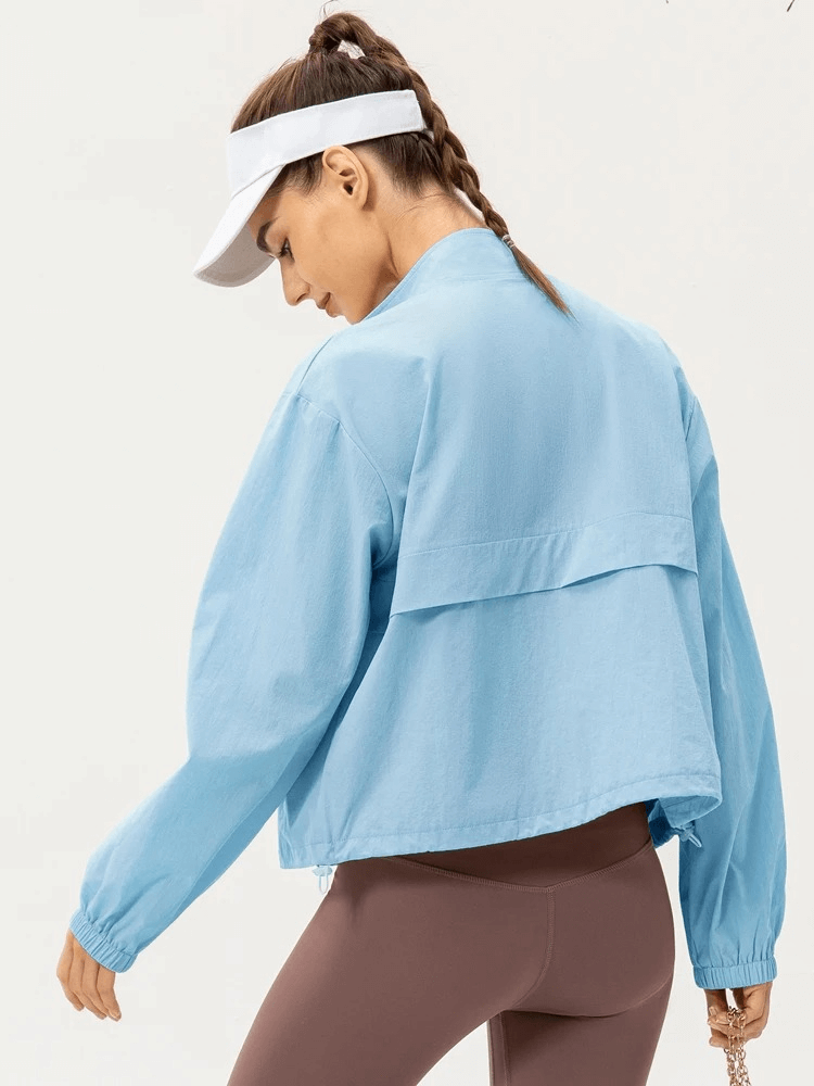Woman wearing blue UV protection running windbreaker and visor, ideal for outdoor sports.